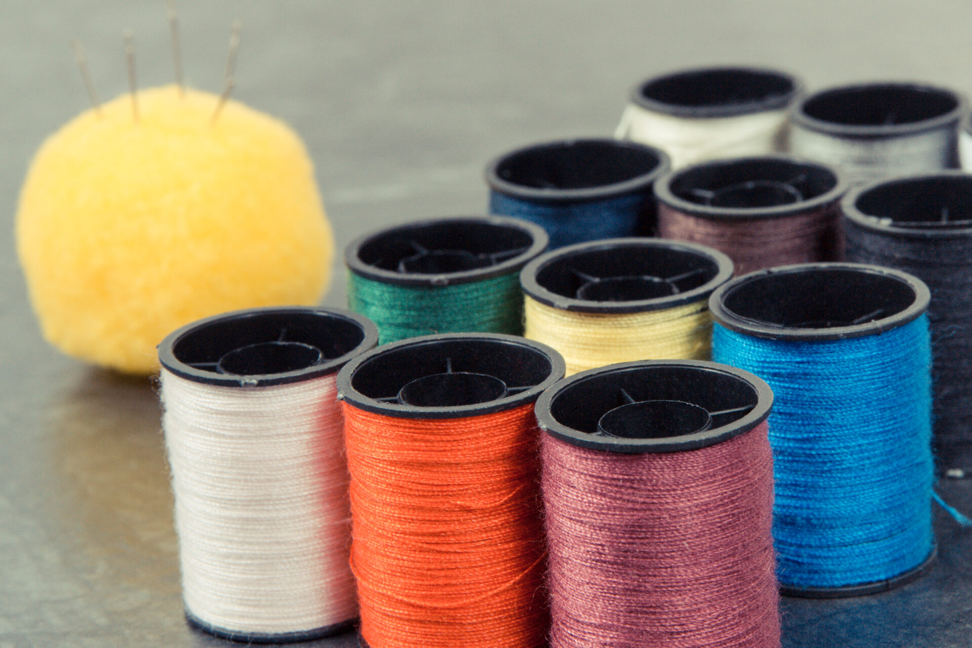 Spools of colorful thread and needle. Accessories for sewing, needlework and embroidery